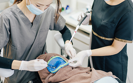 三好歯科自由が丘根管治療でのラバーダム防湿をする歯科医師の画像